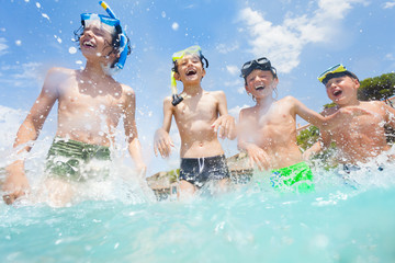 Boys wear scuba mask play in the sea and laughing