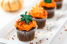 Autumn Delicious Cupcakes Decorated With Orange Frosting, Colorful Sprinkles And Maple Leaves