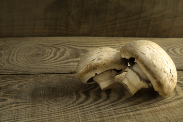 white mushrooms champignons on a wooden table