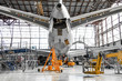 Large passenger aircraft on service in an aviation hangar rear view of the tail, on the auxiliary power unit.