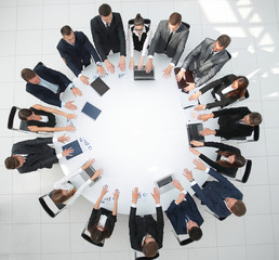 Canvas Print - group of business people sitting at the round table, and putting his palms on the table