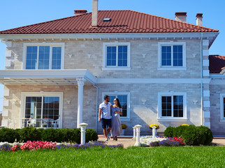 Loving couple walking on path in front of modern house