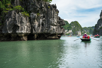 halong bay in vietnam, unesco world heritage site, with tourist rowing boats