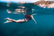 © artifirsov - Slim woman swimming in ocean, underwater photo