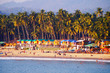 Palolem beach, South Goa, India. One of the best beaches in Goa. Colorful beach huts and palm trees on the coast. Luxury leisure.