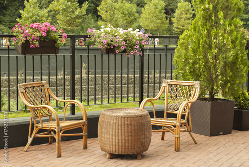 Wicker Outdoor Furniture Two Chairs And A Round Table Stand On The Pedestrian Promenade Of A Small River On A Sunny Day Buy This Stock Photo And Explore Similar