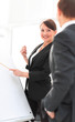 © ASDF - smiling businesswoman showing colleague information on the flipchart.