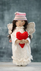 Wall Mural - Handmade toy angel in white dress with red heart and hat