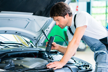 Wall Mural - Mechanic man with diagnostic tool in car workshop