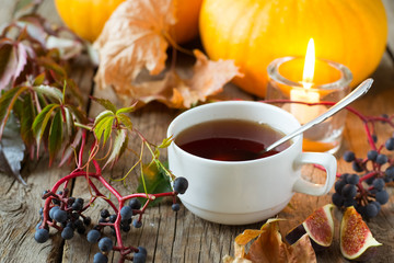 Wall Mural - Tea cup on wooden table with autumn leaves