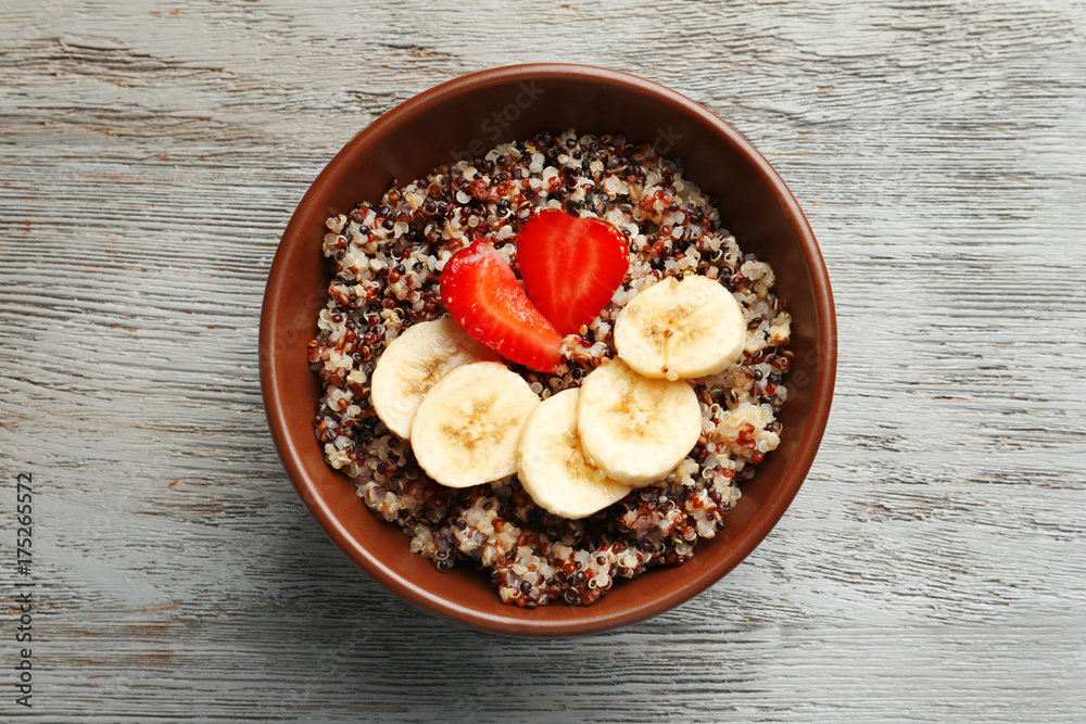 Tasty quinoa in bowl on wooden table