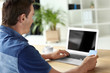 © Africa Studio - Man holding credit card while using laptop indoors