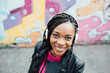 © michela ravasio/Stocksy - Smiling african woman listening to music outdoors