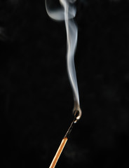 Smoking match on black background