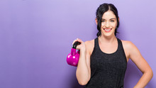 Happy Young Woman Working Out With A Kettlebell