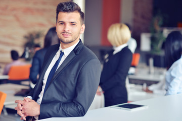 Portrait of an handsome businessman in front of his team