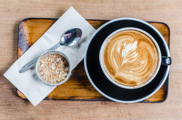 Wall Mural - coffee latte art on wood table in cafe, selective focus top view