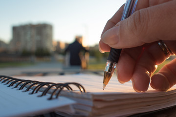 Close-up, writing in a notebook, develop plan of action