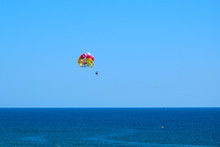 Tourists Fly Over The Sea On A Parachute Behind A Boat (Paraseyling).