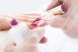 Manicure żelowy, kosmetyczka przedłuża paznokcie. Zabieg pielęgnacyjny dłoni i paznokci, kobieta u kosmetyczki na zabiegu manicure.