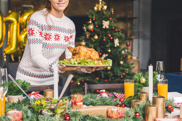 woman serving christmas table with chicken