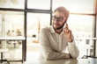 © NDABCREATIVITY - Handsome businessman using phone and wearing glasses
