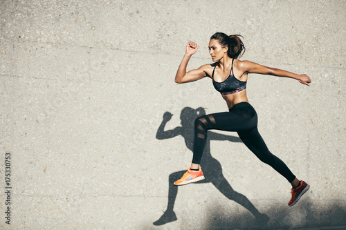 Fotomural Fit young woman jumping and running