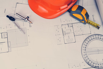 Helmet and measurement tool on blueprint, architectural concept