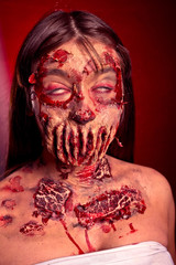 Wall Mural - Zombie girl with sad eyes on a red black background, image on Halloween