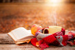 © Cherries - Open book with apple and yellow tea mug with warm scarf