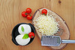 © whiteaster - Mozzarella cheese balls and grated mozzarella on wooden table overhead view