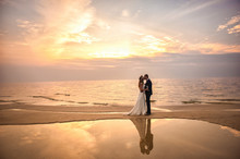 Bride And Groom, Newlyweds, Honeymoon On The Beach Sunset Sun