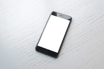 Poster - Black mobile phone on white wooden desk mockup.