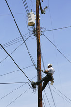 Man Hanging  On A Telephone Pole Working