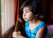 © saptakganguly/Stocksy - Cute little girl looking through the window contemplatively