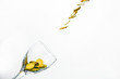 Golden coins splash in a glass of champagne on the wall background with copy space.