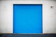 Blue Industrial Roll Up Door Inset In Brick Wall