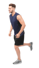 Wall Mural - Young man in sportswear running against white background