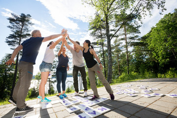 Friends Giving High-Five After Solving Crossword Puzzle On Patio