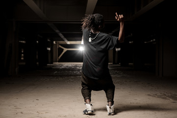 Dancing african american guy in black clothes