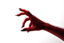 Halloween Red Devil Monster Hand With Black Fingernails Against A Plain Background