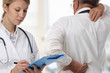 © dream@do - Female Doctor and senior male patient suffering from back pain during medical exam.