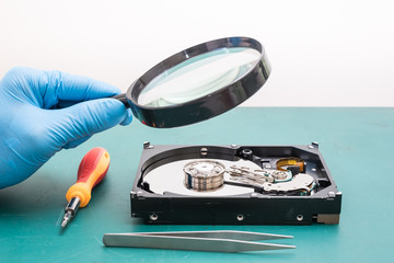 The abstract image of perspective inside of hard disk through a magnifying glass in the lab and green copy space is backdrop. the concept of data, hardware, technician and technology.