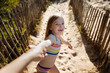 © Lisa Tichané - Smiling little girl holding her mother's hand on a sandy path