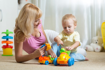 Poster - cute mother and child boy playing together indoors at home