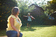 © Connect Images - Mature woman watching son running in garden in pilot costume