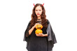 © Mediaphotos - Young woman in Halloween costume posing against white background in studio