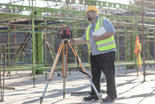 Construction Worker Using Surveying Equipment