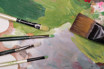 Artist paint brushes and oil paint  on wooden artistic palette background. Brush paint artistic. Tools for creative work. Back to school. Paintings Art Concept. Selective focus. Copy space. Top view.