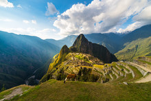 Machu Picchu Illuminated By The Warm Sunset Light. Wide Angle View From The Terraces Above With Scenic Sky And Sun Burst. Dreamlike Travel Destination, World Wonder. Cusco Region, Peru.
